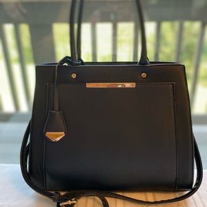 Black handbag with gold trim and multiple pockets.